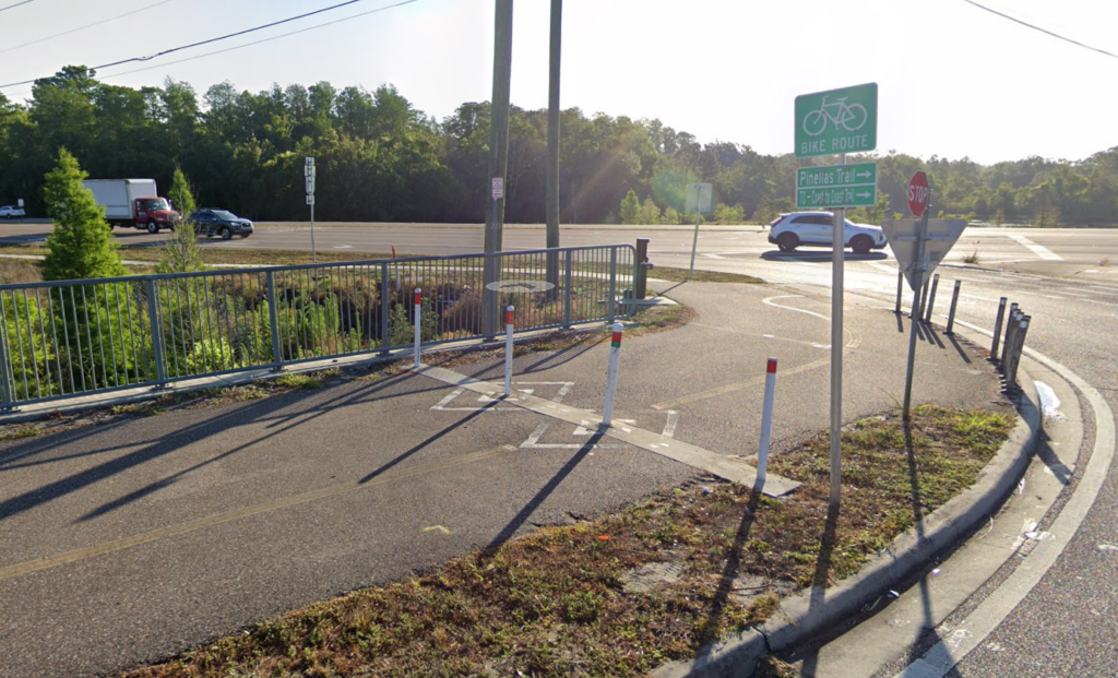 Google street view image of guardrails and pedestrian trail stripes along Keystone Road.